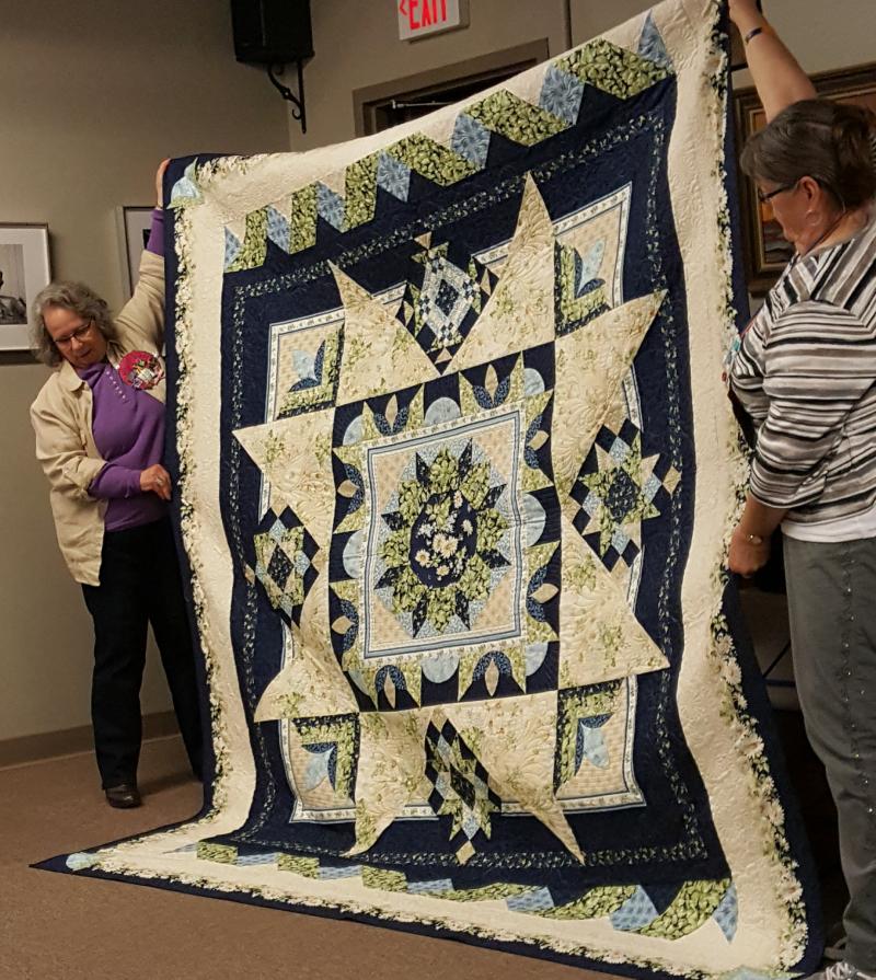 Babbette and Marsha are displaying the 2020 Serendipity quilt, donated by Babbette. 