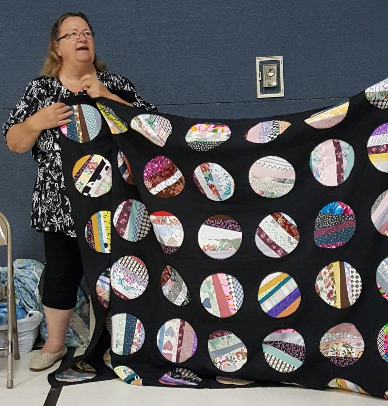 Pat shows a striking string quilt of  appliqued circles
