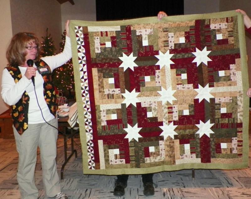 Carol L shows jelly roll Christmas quilt.