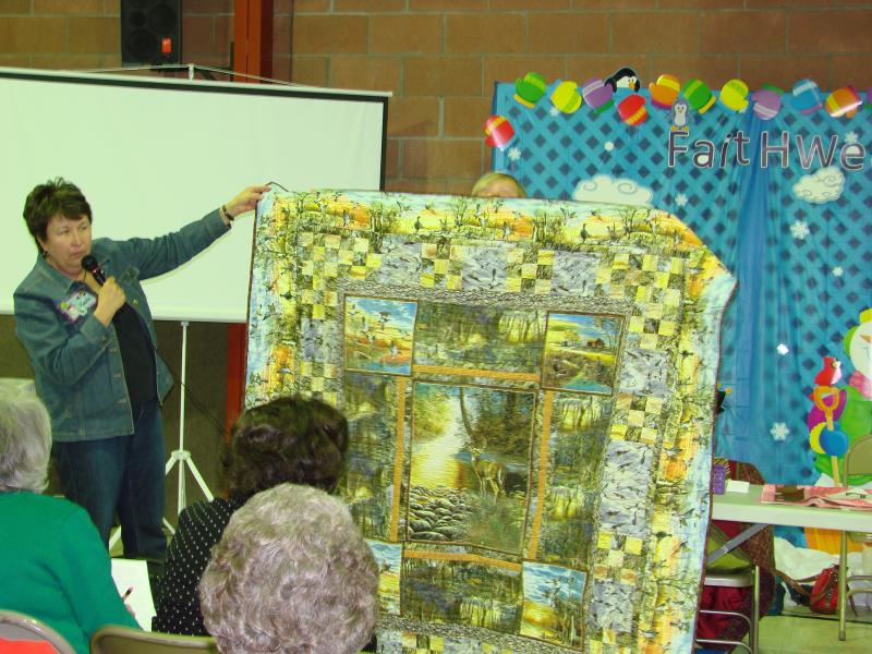 Linda showing Sydney S. quilt she made for her dad for Christmas