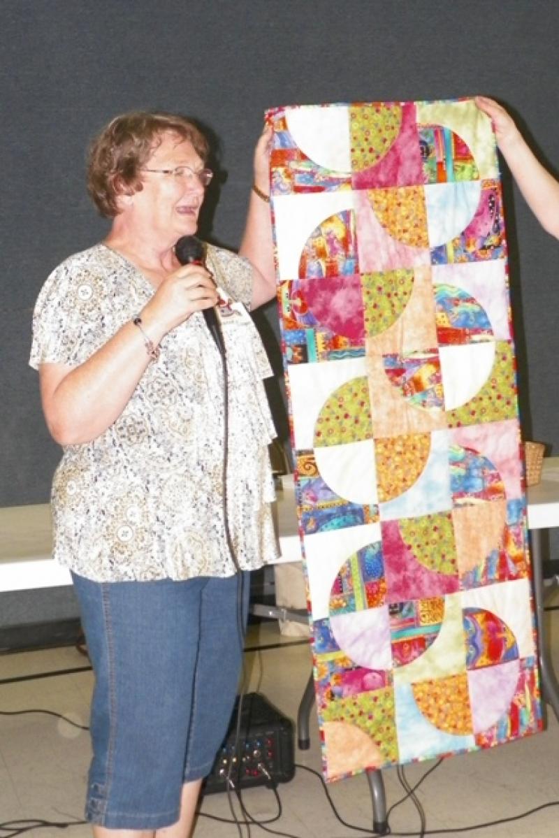Diane C shows her table runner from Vickie W. class.
