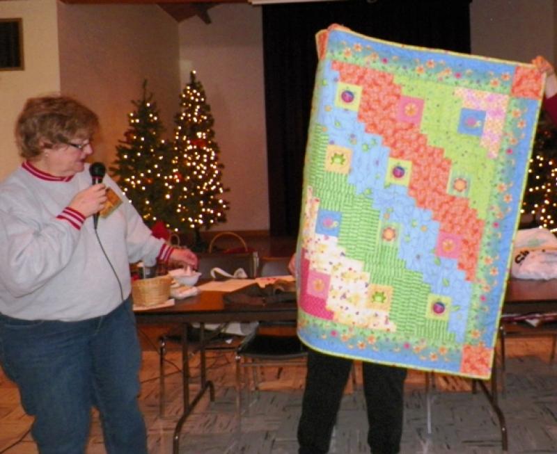 Kathy Mc shows a quilt made for Molly