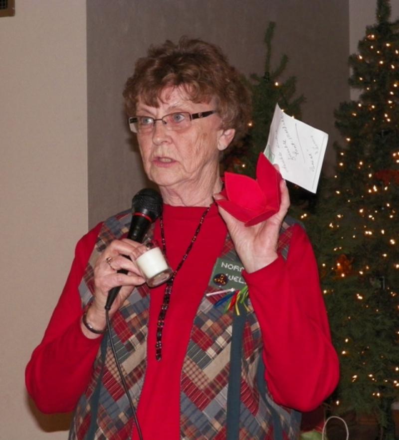 Norma W. shows a Poinsettia blossom candle holder and a purple jacket. 