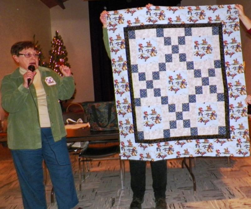 A baby quilt with cowboy theme and a round tuit shown by Patsy S.