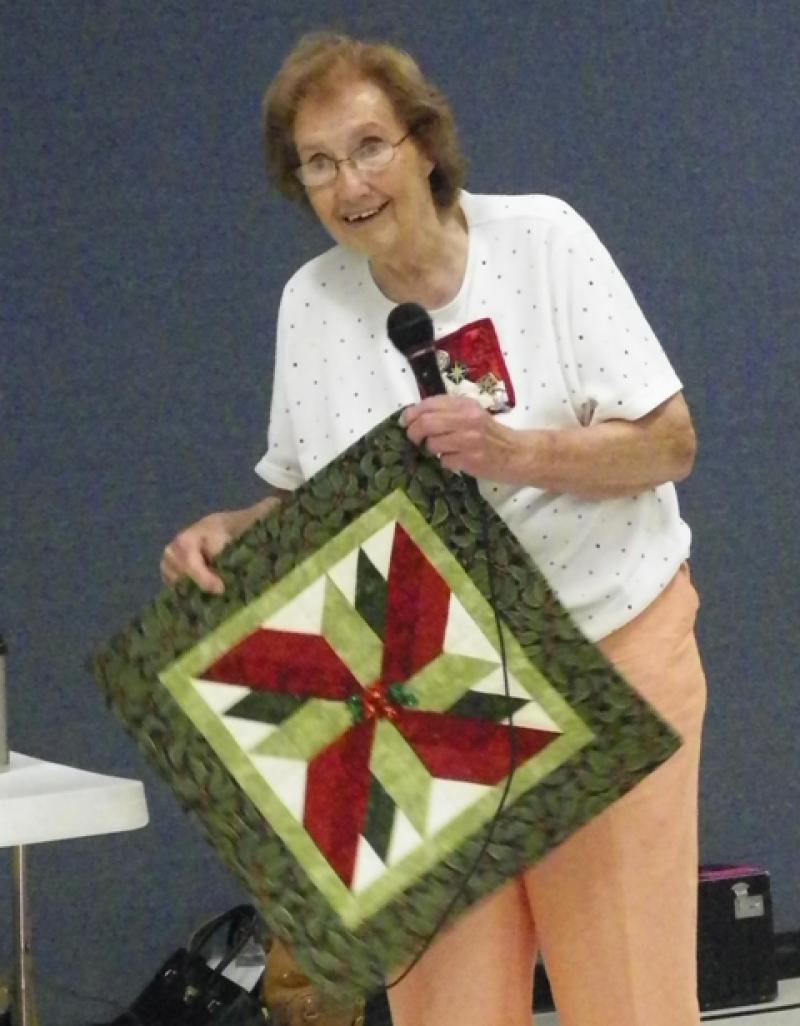 Stella S  shows a Christmas item for Silent Auction.