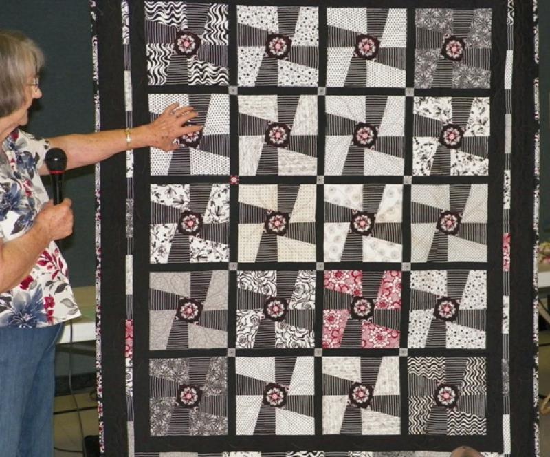 Eileen T shows a Black & White quilt made by Sharon A for Silent Auction.